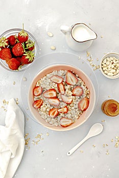 Oatmeal porridge with summer strawberries berries. Porridge oats in bowl with honey,milk,nuts. Healthy food breakfast,lifestyle,