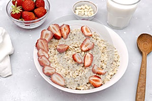 Oatmeal porridge with summer strawberries berries. Porridge oats in bowl with milk,nuts. Healthy food breakfast,lifestyle,dieting