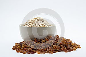 Oatmeal and raisins on a white background. Healthy diet.