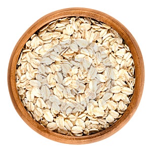 Oatmeal, rolled oats in wooden bowl over white