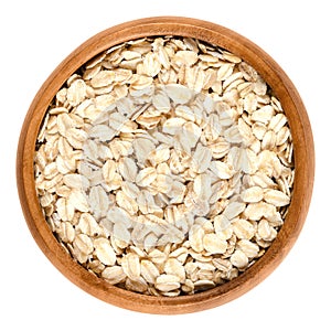 Oatmeal, rolled oats in wooden bowl over white photo