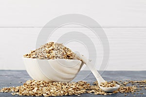 Oatmeal in a white bowl with a glass of milk on a white blue background. A healthy, nutritious morning breakfast. Oat milk. Health