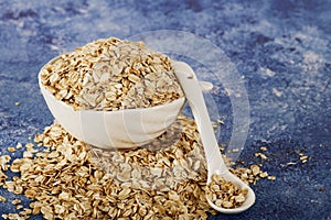 Oatmeal in a white bowl with a glass of milk on a white blue background. A healthy, nutritious morning breakfast. Oat milk. Health