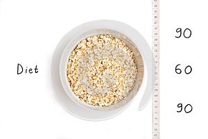 Oatmeal in white plate, centimeter and inscription on white background