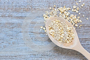 Oatmeal in a wooden spoon on the kitchen counter in blue rustic vintage colour. Selected focus. Healthy food concept