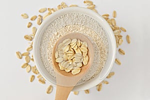 Oatmeal on wooden spoon and oat flour in bowl