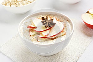 Oats porridge with red apple slices and cinnamon photo