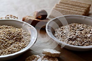 Oats and rice in a bowl. Rice cakes and bread in background. Foods high in carbohydrate.