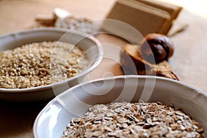 Oats and rice in a bowl. Rice cakes and bread in background. Foods high in carbohydrate.