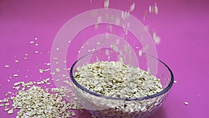 Oats that in a transparent plate and oats that fall to the plate on a lilac background photo