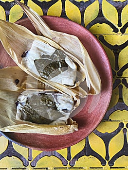 Oaxacan tamales with hoja santa wrapped on the outside of the masa photo
