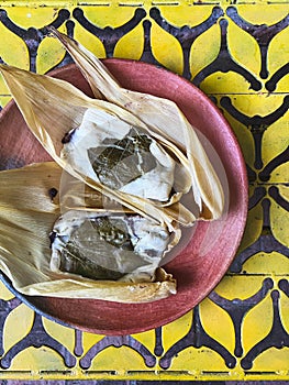 Oaxacan tamales with hoja santa wrapped on the outside of the masa photo