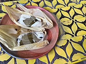 Oaxacan tamales with hoja santa wrapped on the outside of the masa photo