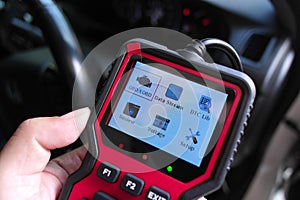 OBD2 scanner in hand, car diagnostic tool and code reader to check engine light, read and clear DTCs
