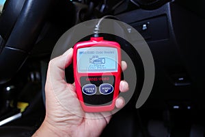 OBD2 or OBD scanner in a auto mechanic hand for engine system analysis