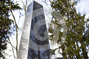 Obelisk of granite against background of forest. Place of military glory. Monument to soldiers