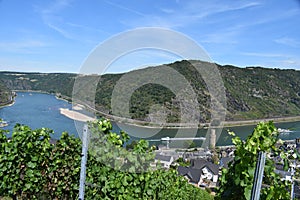 Oberwesel, Germany - 07 22 2020: Mittelrheintal with a river curve, river banks, Ochsenturm in Oberwesel and ships passing