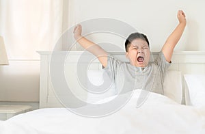 Obese boy wake up yawning and stretch