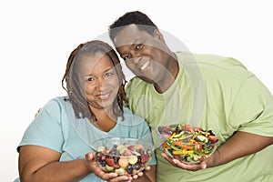 Obese Couple Holding Bowl Of Salad