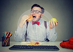 Obese employee eating fast food at workplace