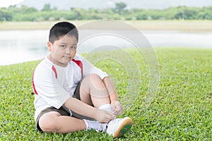 Obese fat asian boy lacing sport shoe.