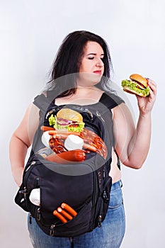 Obese fat young woman with a great backpack full of junk food on