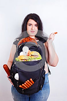 Obese fat young woman with a great backpack full of junk food on