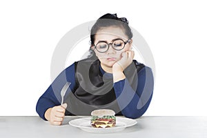 Obese female hesitate eat cheeseburger photo