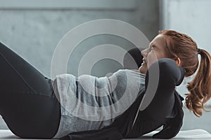 Obese girl performing sit ups