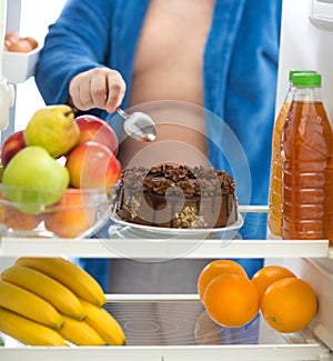 Obese guy prefer chocolate cake from fridge than fruit