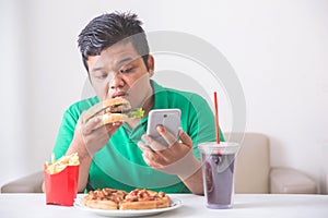 Obese man eating junk food