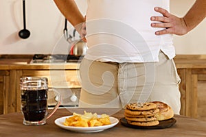 Obese man fighting the temptation to eat junk food