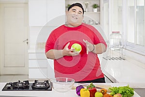 Obese man holding a cabbage to make a salad