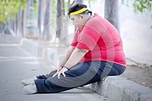 Obese man looks tired after running in the park