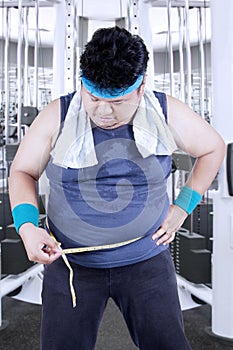 Obese man measuring his belly 1