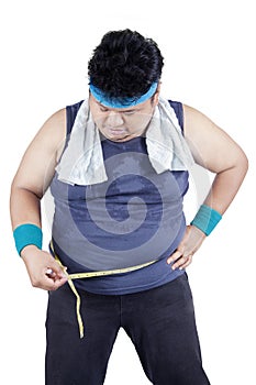 Obese man measuring his belly 2