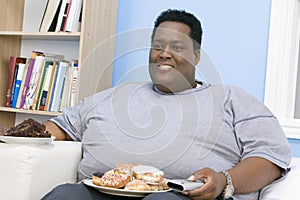 Obese Man Sitting On Sofa