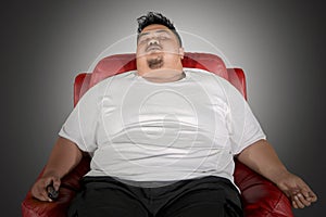 Obese man sleeping on the armchair