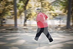 Obese man sprinting with dumbbells in the park