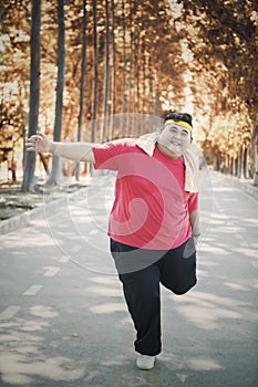 Obese man warming-up his feet before exercising