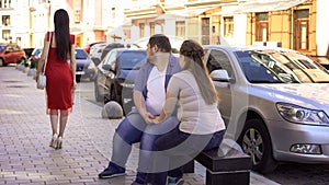 Obese man and woman looking at slim lady passing by, jealous of fit shape