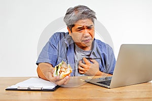 Obese men do not eat time to eat.hamburger while sitting at work on laptop