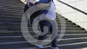 Obese people walking on stairs, overweight problem among youth, consumerism