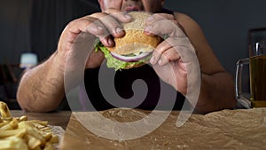 Obese person biting big burger, addicted to unhealthy junk food, overeating