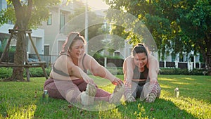 Obese two young asian woman doing stretching leg in the park, woman with overweight warm up and exercise.