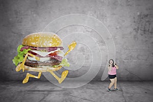 Obese woman being chased by a cheeseburger