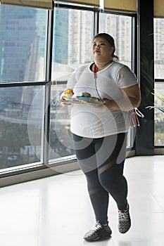 Obese woman carrying foods in the restaurant