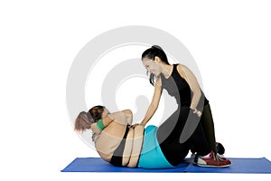 Obese woman doing crunches on studio