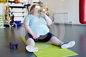 Obese Woman Drinking Water after Workout