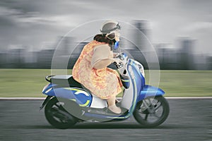 Obese woman driving a scooter with high speed